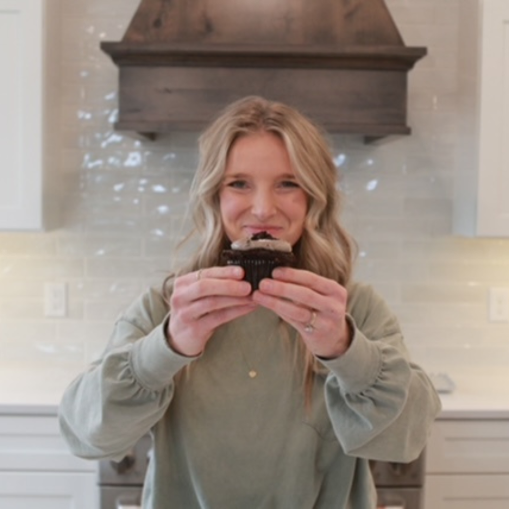 Girl holding a cupcake to the camera