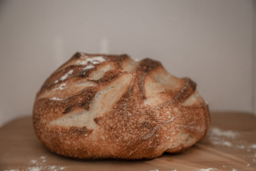 close up of a rustic sour dough bread loaf sprinkled with flour 