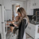 Mom holding her baby opening fridge