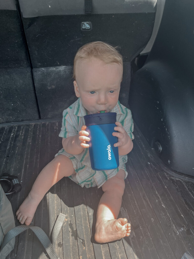 baby drinking from blue owala water bottle