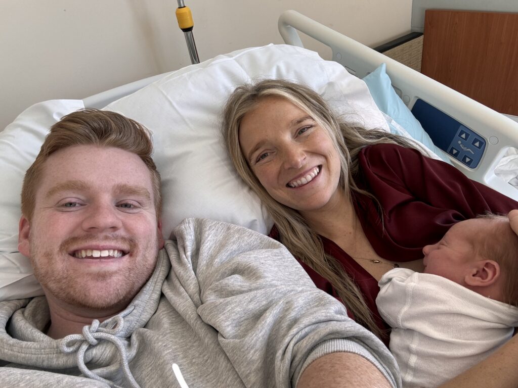 Mom and dad in hospital bed with their newborn baby