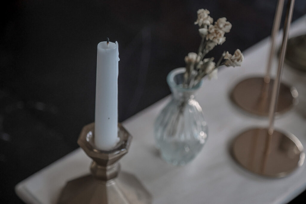 Pretty table centerpiece with candle and vase holding dried flowers 