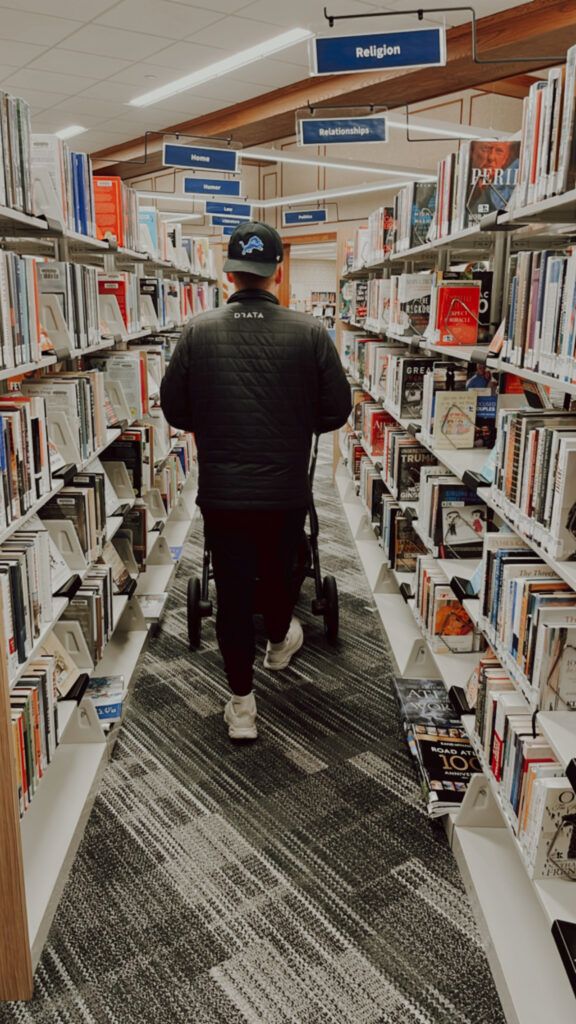 Dad pushing stroller through library