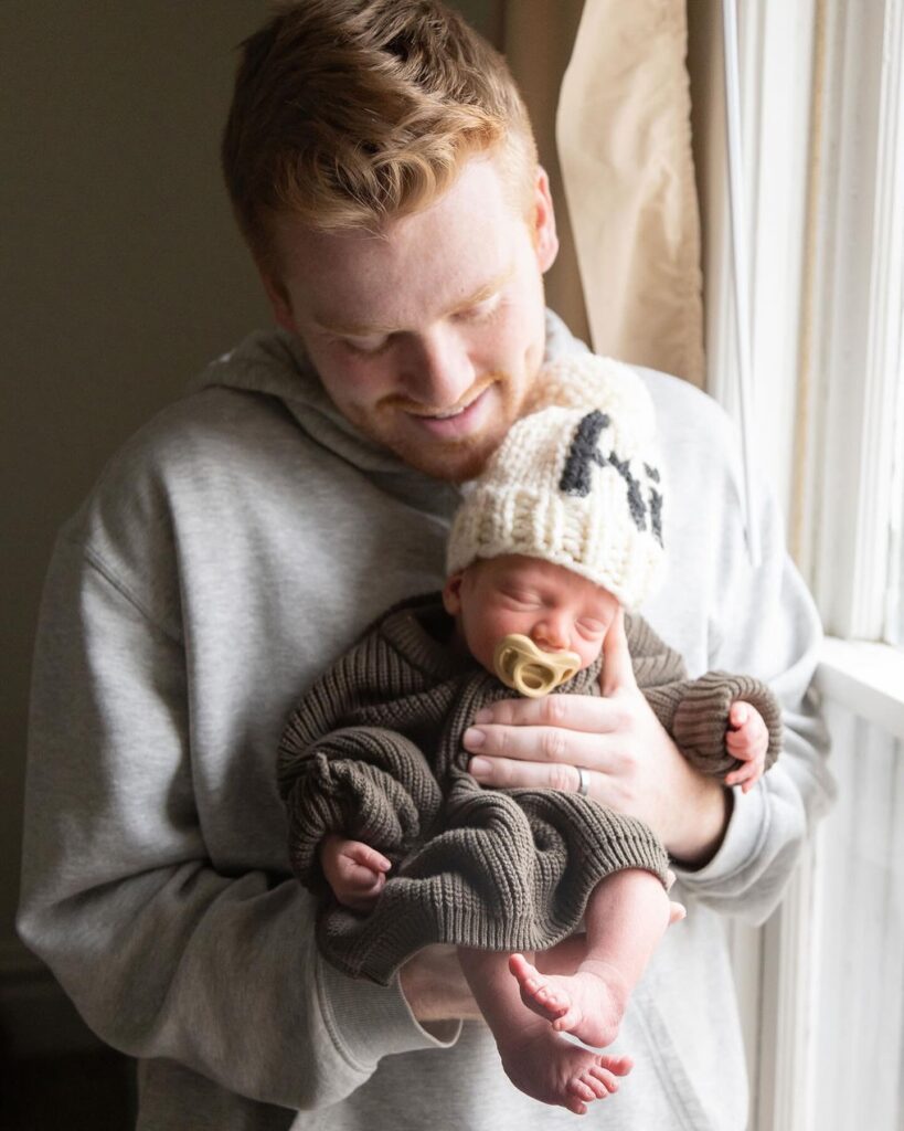 Dad holding and looking lovingly at at newborn son