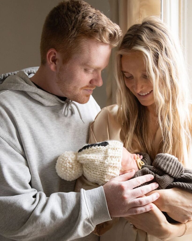 New mom and dad looking lovingly at newborn son