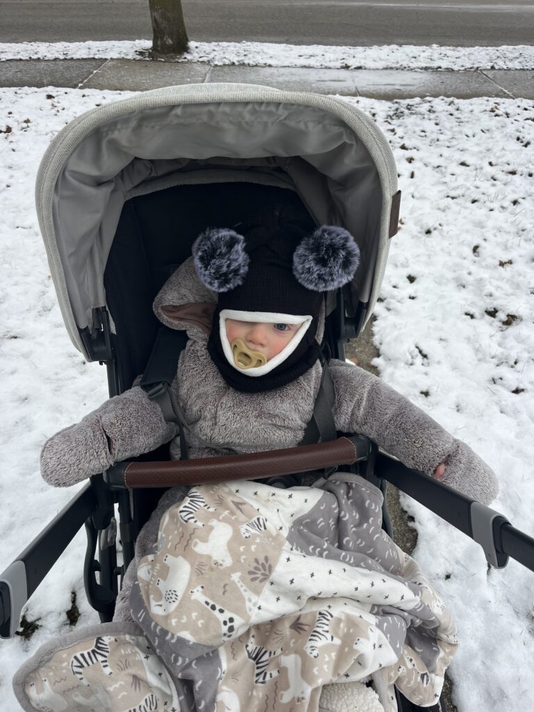 Cute baby bundled up in stroller 