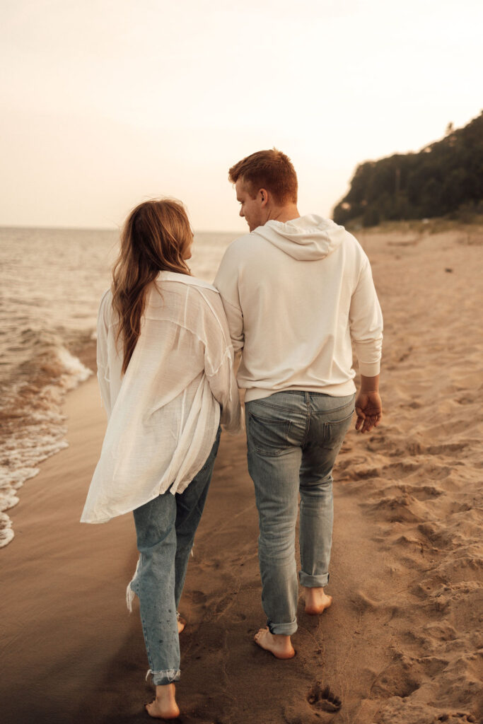 Husband and wife walking away from the camera at the beach