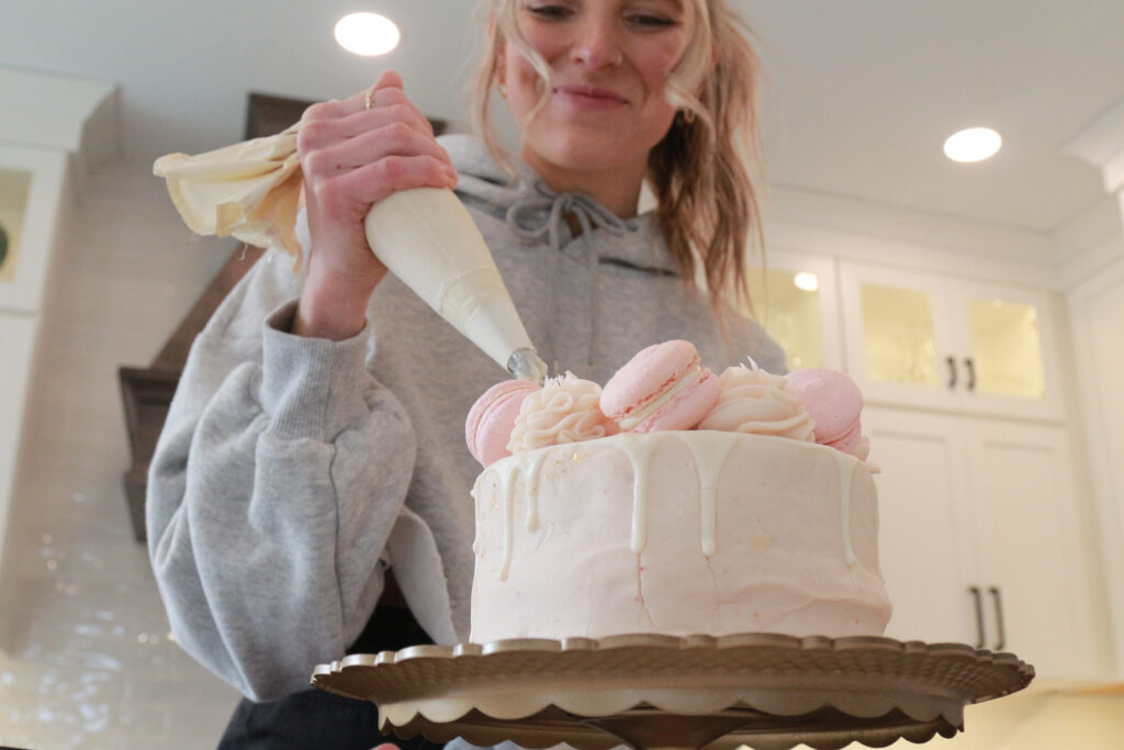 Girl decorating a cake smiling 