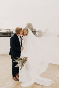 Husband and wife on their wedding day - husband kissing wife