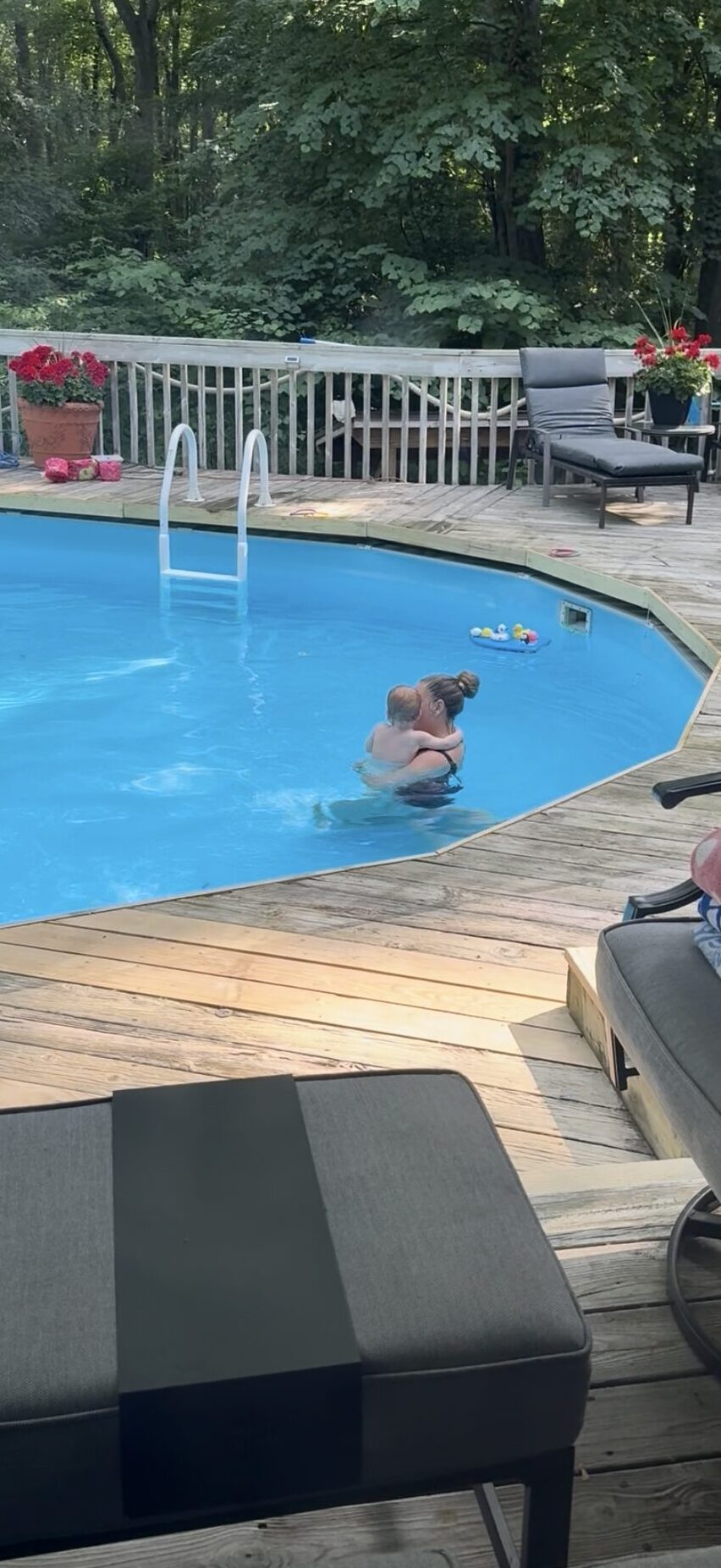18 month old taking swim lessons being held by his teacher
