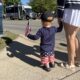 Toddler boy holding an American flag watching the 4th of July parade